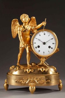 Pendule d'époque Empire en bronze ciselé et doré, présente un amour jouant du tambour.