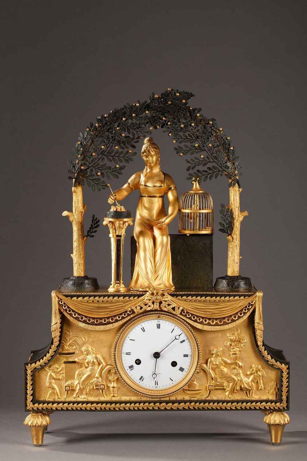 Pendule en bronze doré, patiné et ciselé. Epoque Empire Joséphine est assise sous une gloriette et donne la becquée à des oisillons.