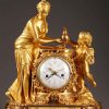 Pendule en bronze doré et ciselé d'époque Louis XVI. Vénus penchée, les mains au dessus d'une vasque attend que Cupidon, dans les nuées, lui verse de l'eau à l'aide d'une aiguière, groupe sculpté de Falconnet.